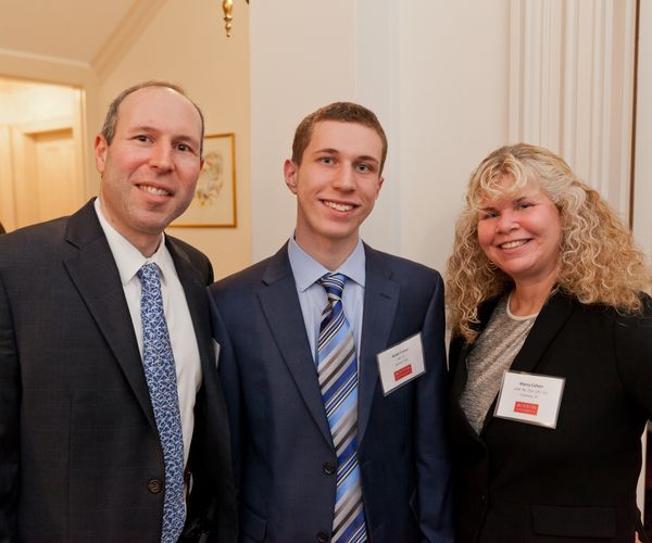 student with his parents, at a formal event